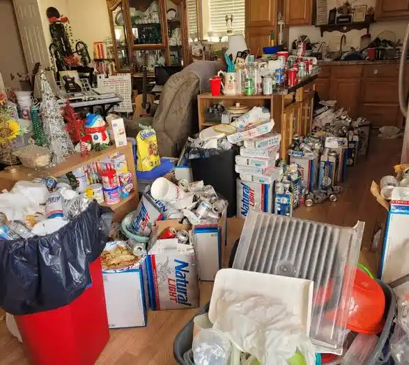 Property cleanout workers sorting and removing accumulated household clutter during a hoarding cleanup